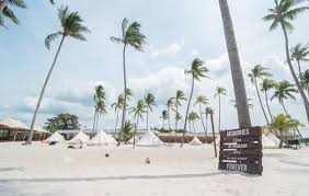 Children playing on Ranoh Island beach with clear turquoise water.